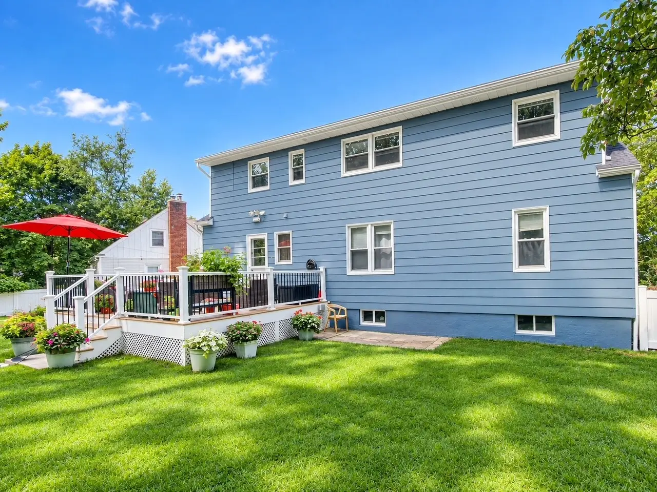 Back of newly painted blue house with deck and lawn in Netcong NJ
